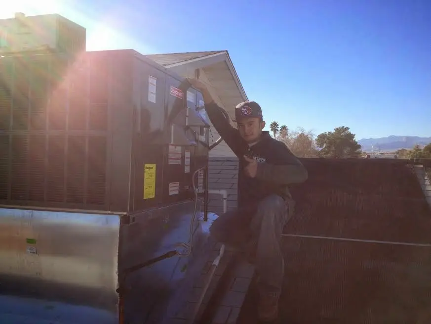 HVAC technician performing Heat Pump Repair on a rooftop unit in Brookfield
