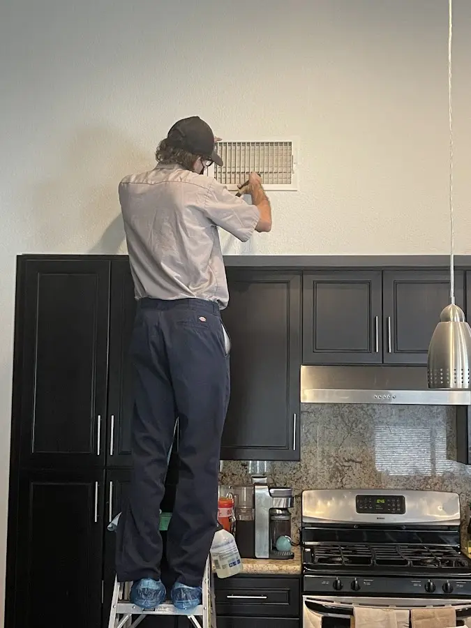 Technician inspecting an air vent during HVAC service in Brookfield